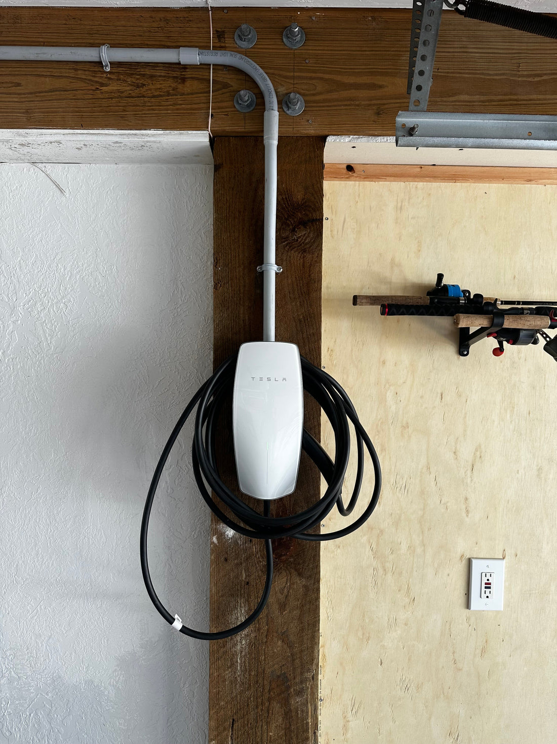 Tesla Wall Connector EV charger professionally installed in the garage of a Galveston beach house with conduit routed from the upstairs electrical panel for a clean, code-compliant installation by ProLectric LLC.