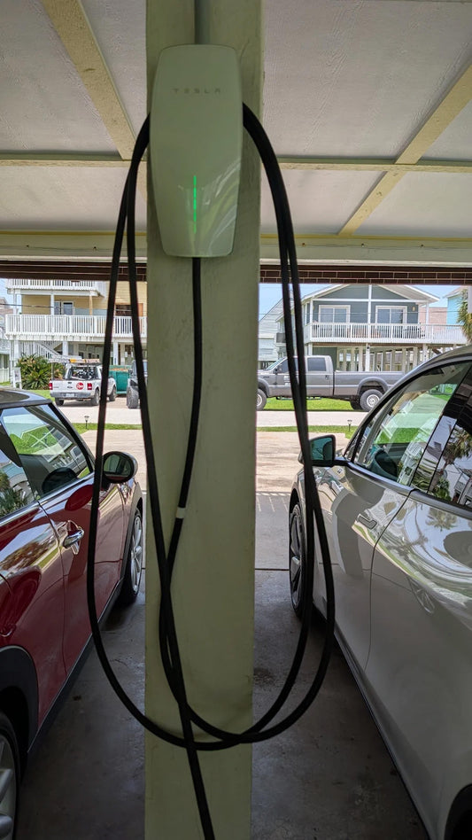 Tesla Wall Connector installed on a support column at a Galveston beach house with a dedicated 50-amp EV charging circuit.